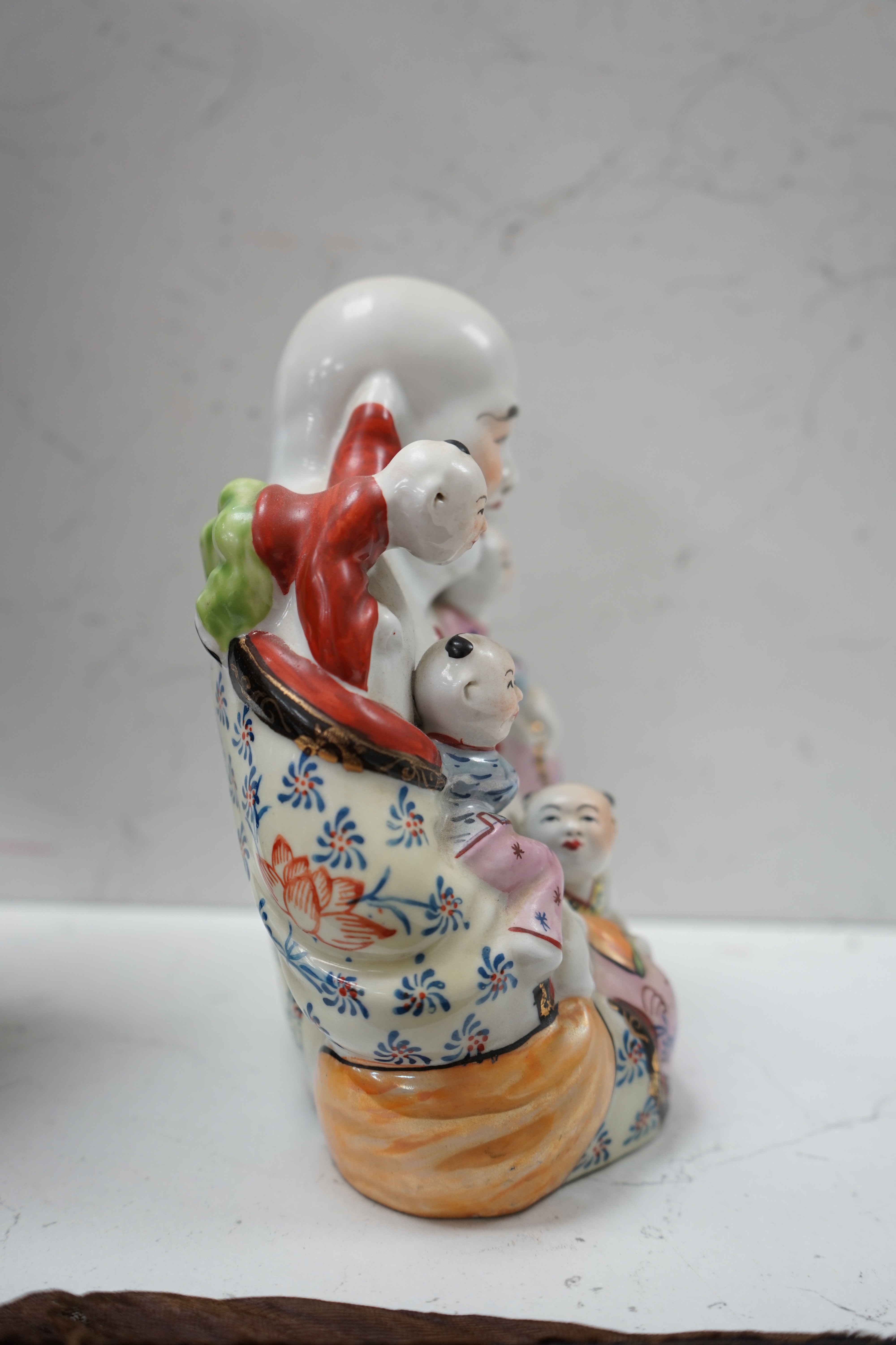 A Chinese enamelled porcelain Budai group, 20cm. Condition - good